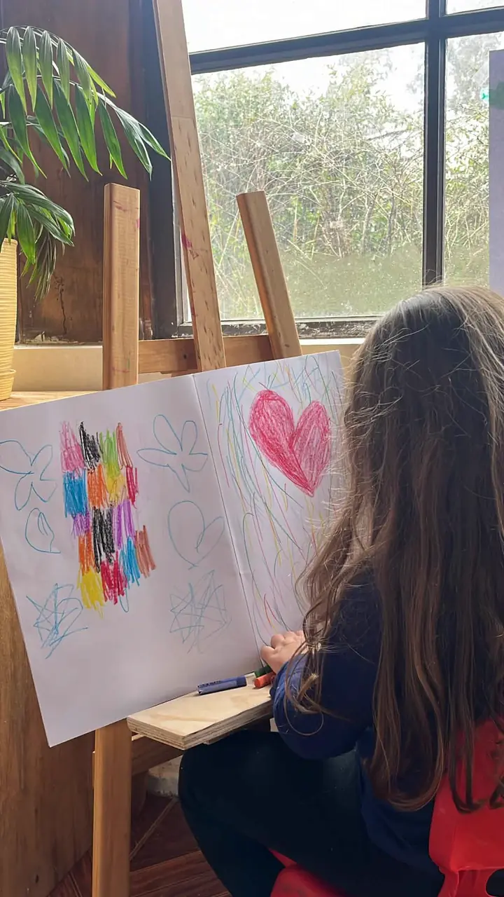 Niña pintando en el caballete