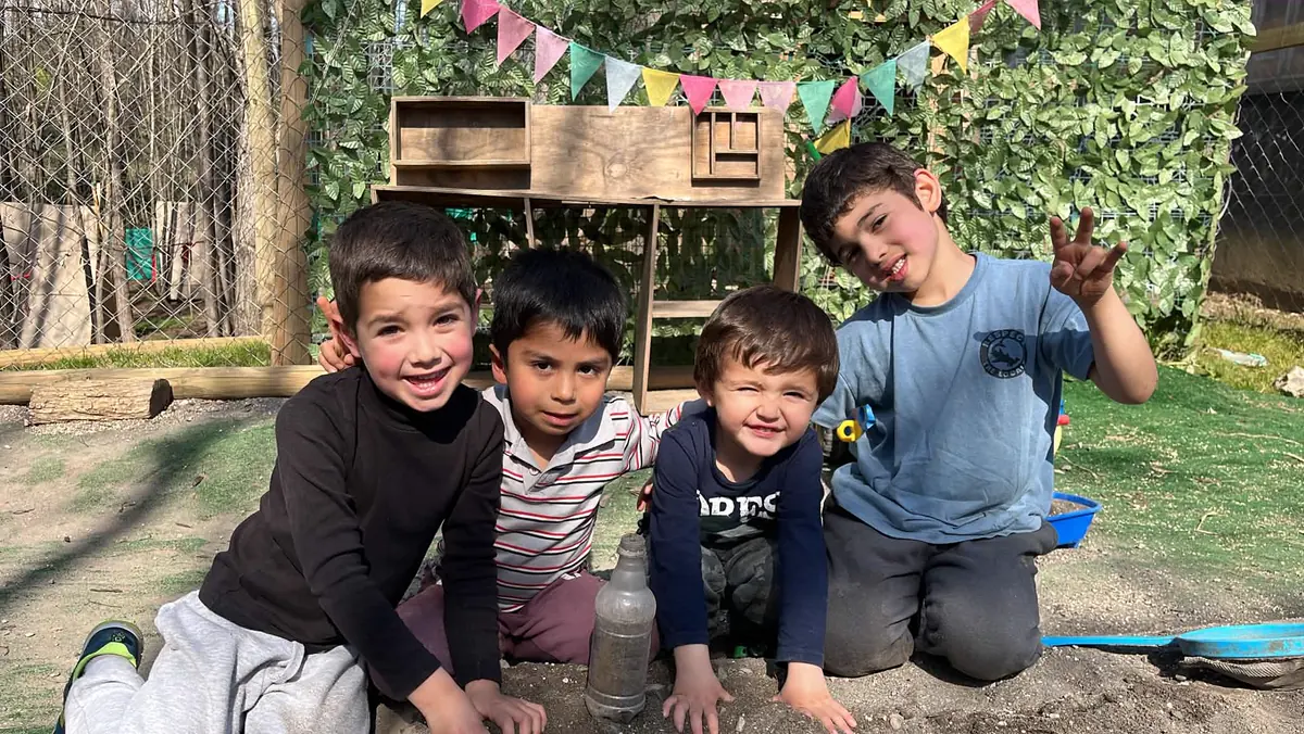 Cuatro niños sonriendo juntos en el huerto