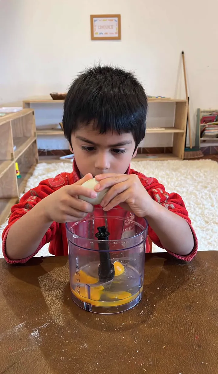 Niño rompiendo un huevo para cocinar